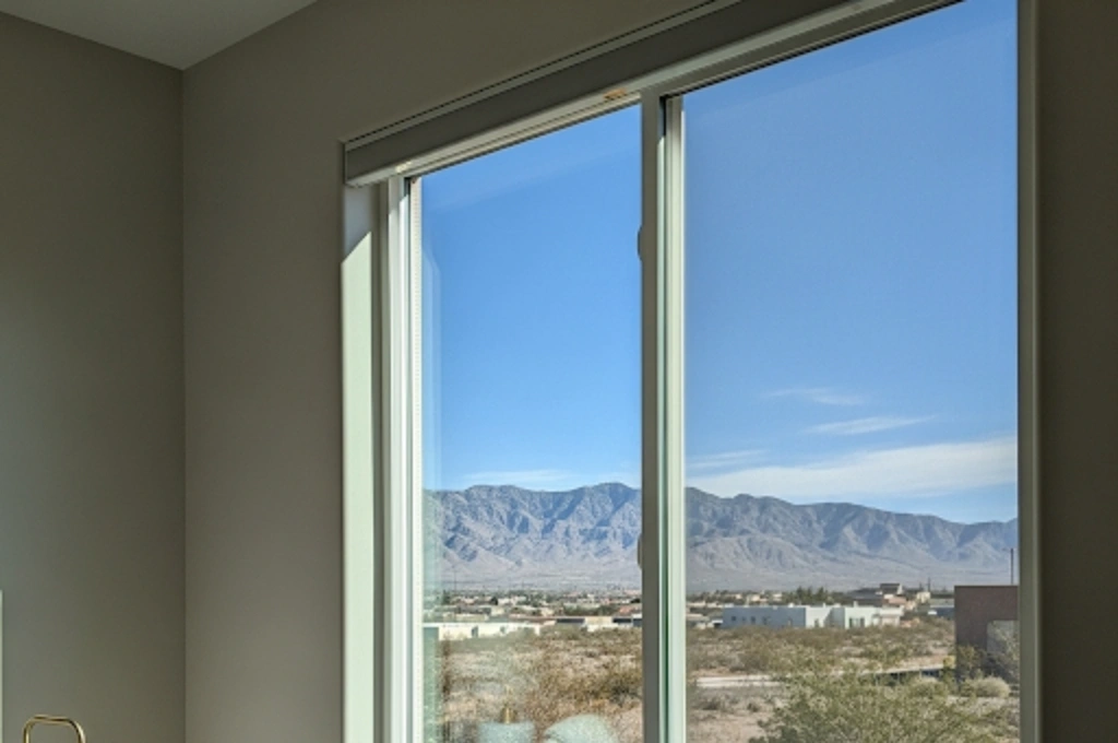 A crystal-clear, newly repaired double-pane window in an gibraltar bedroom, showcasing a perfect view with no fog or condensation.